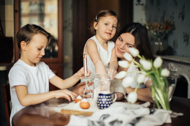 Mother and two children baking together in their kitchen