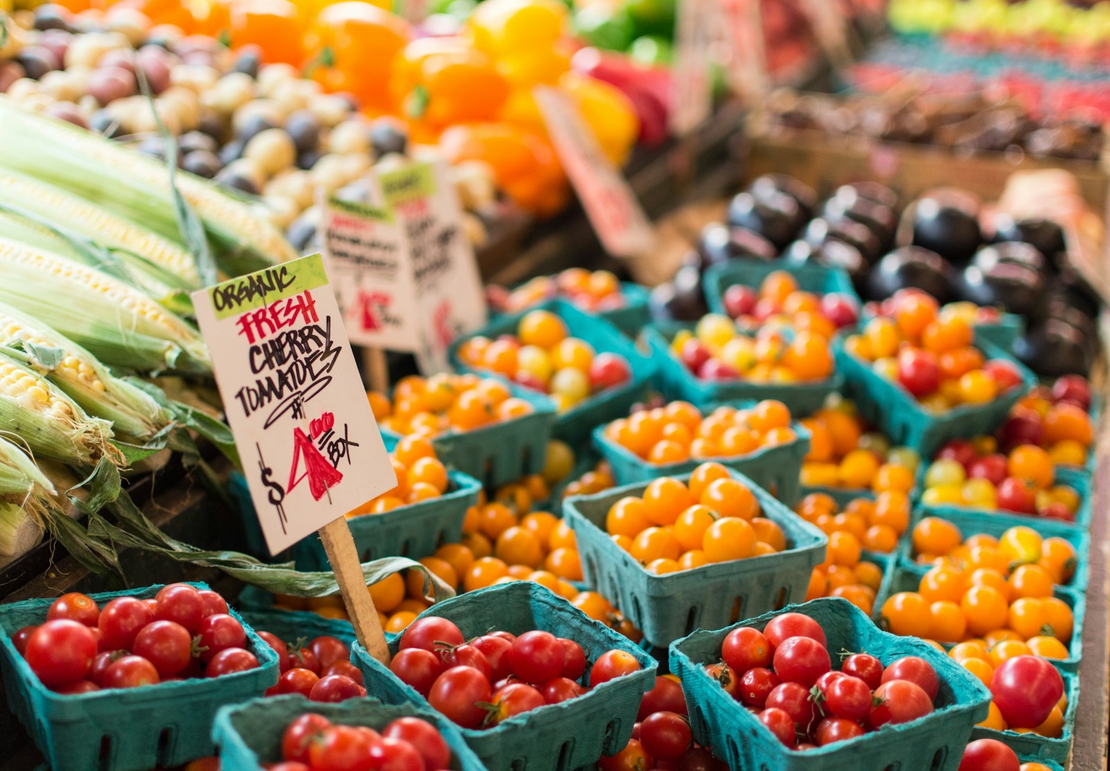 Baskets of red and orange cherry tomatoes at a market